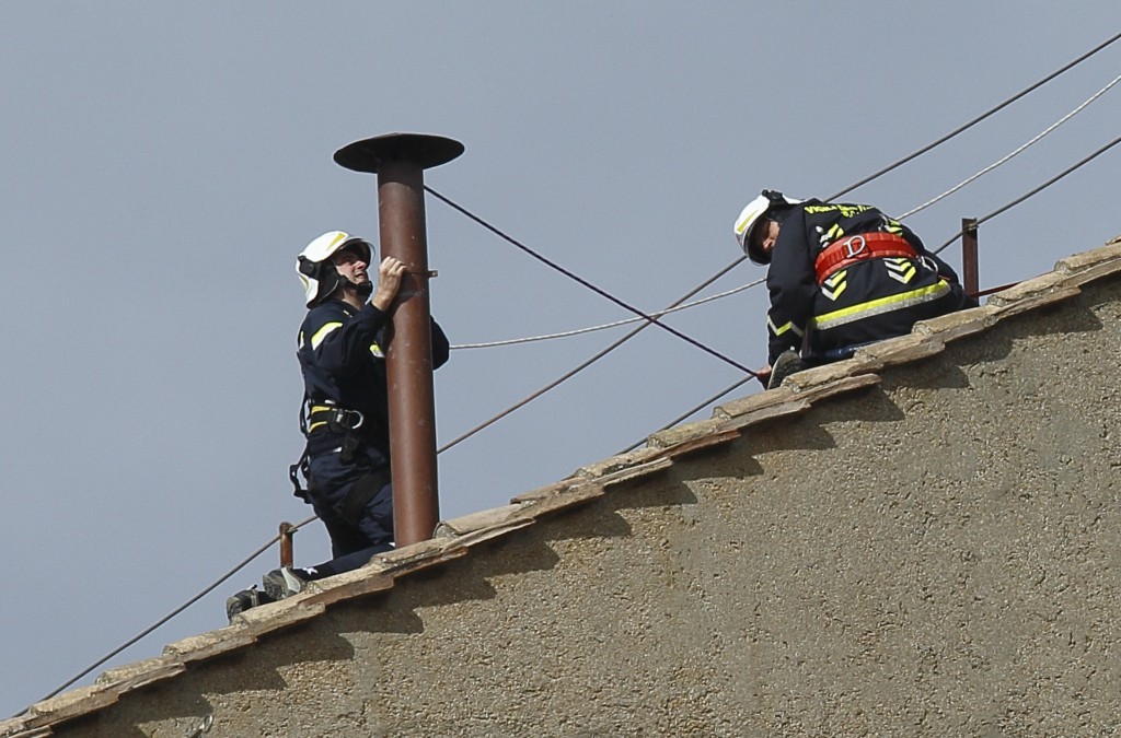 Vatican firefighters place smokestack on roof of Sistine Chapel at Vatican