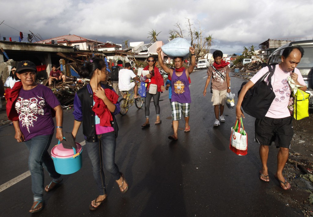 People carry supplies as they walk the street in the typhoon-battered city of Tacloban, Philippines, Nov. 13. Hundreds of thousands of people in Leyte province had been displaced by Typhoon Haiyan, one of the worst storms to hit land.