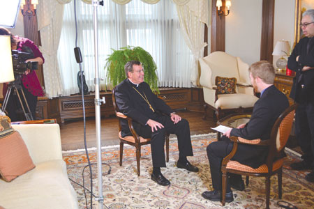 Archbishop Vigneron laughs during a break in taping an interview with Michigan Catholic managing editor Mike Stechschulte on CTND. “Was I slouching?” he jokingly asked the CTND crew.  