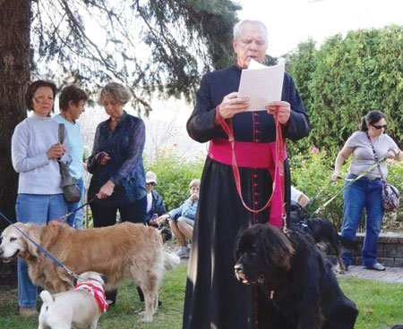 Msgr. William Easton is seen during a blessing of animals in this file photo. With him is his beloved Newfoundland, Lord Stanley, or “Stachu,” as he is known to the parishioners he often greeted with the animal-loving pastor at Shrine. 
