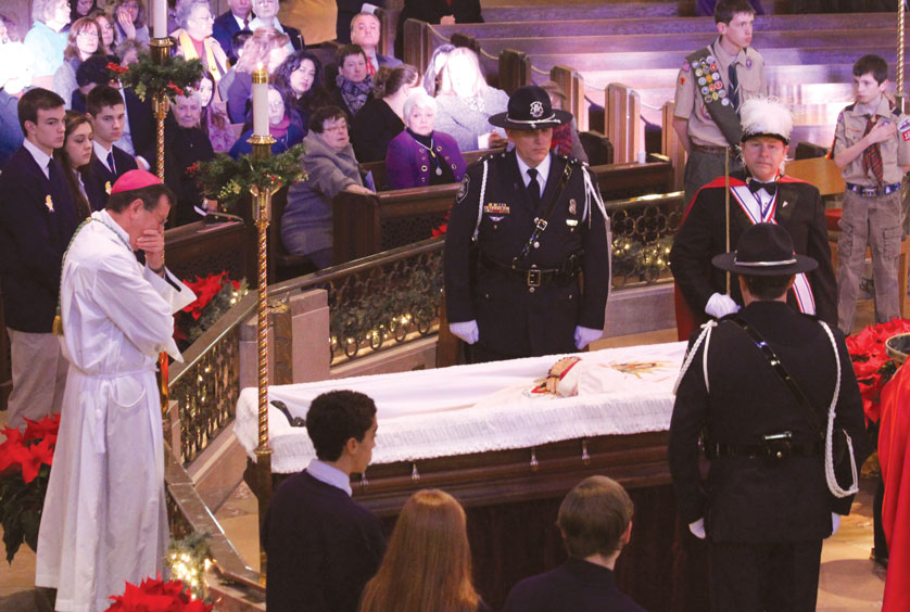 Archbishop Allen Vigneron weeps in front of the casket of Msgr. William Easton before the Jan. 3 funeral Mass at the National Shrine of the Little Flower in Royal Oak. Msgr. Easton, the parish’s longtime pastor, died Dec. 29 after suffering a cardiac ailment Dec. 20.