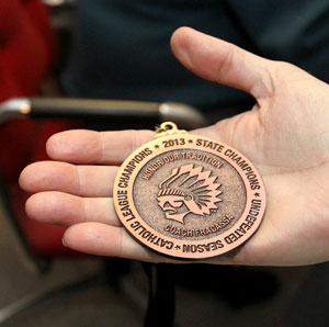 The 2013 state championship medal earned by Al Fracassa and the Brother Rice Warriors, who went undefeated in the coach’s last season. 