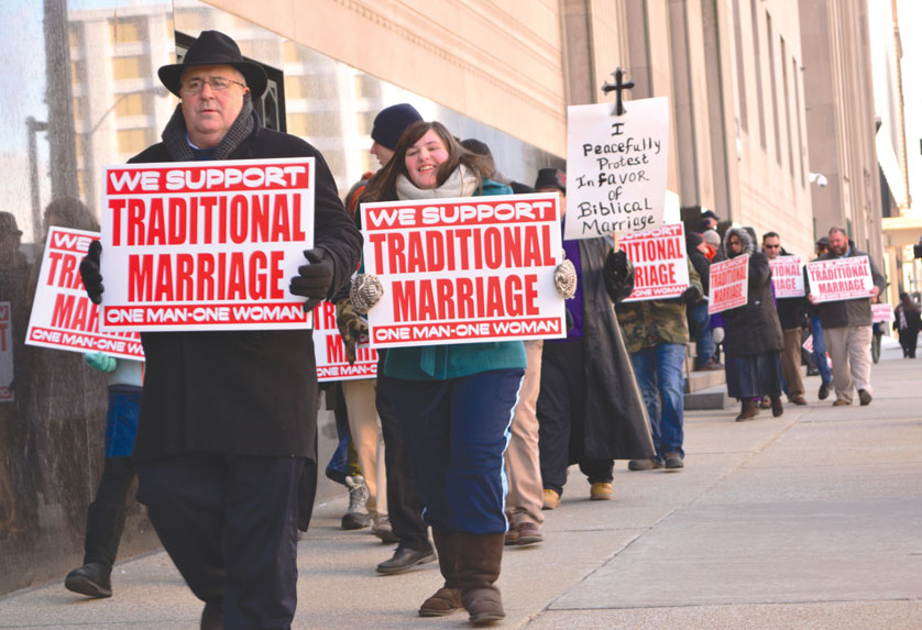 Dozens of protesters hold signs while marching to supporting Michigan’s marriage amendment Feb. 25 in front of the Theodore Levin U.S. Courthouse in downtown Detroit.  