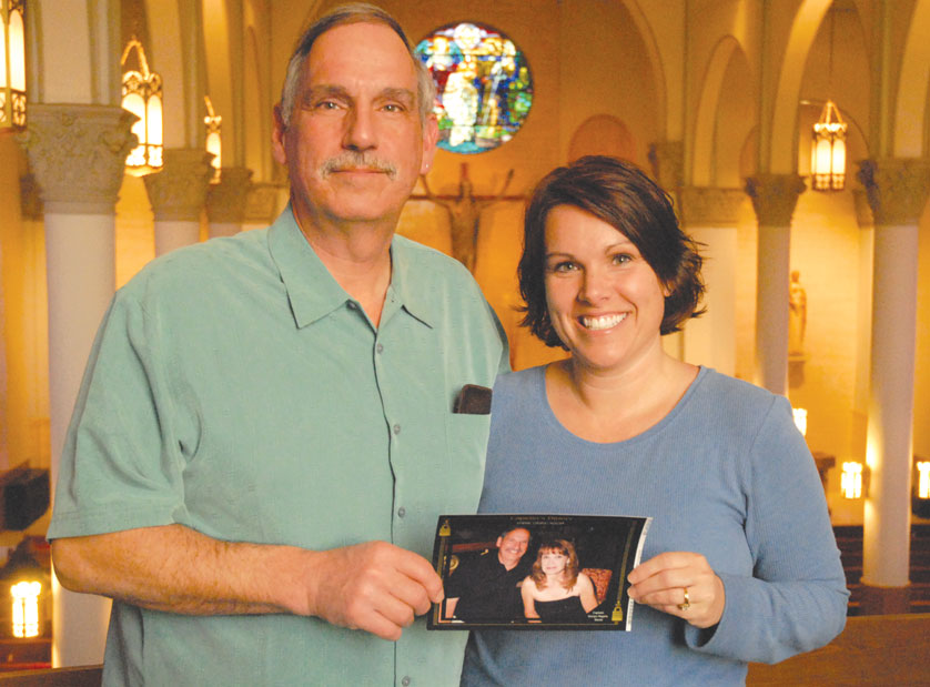 David Cupp and his daughter, Melissa Maniaci, hold a photo of David and his late wife, Diana, on one of their many cruises taken during Diana’s life. This photo was taken at St. John the Baptist Parish, Monroe, where David is attending RCIA classes.  