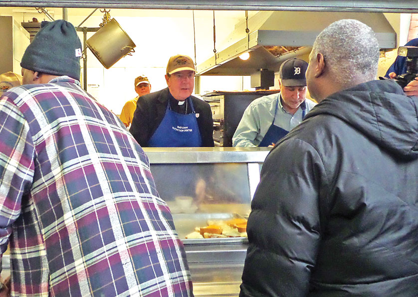 Archbishop Allen H. Vigneron serves food March 4 at the Matachan Nutritian Center, a service of the Society of St. Vincent de Paul, in Pontiac. The archbishop helped volunteer at the center, which serves meals to those in need every Tuesday and Thursday, in preparation for Lent.  