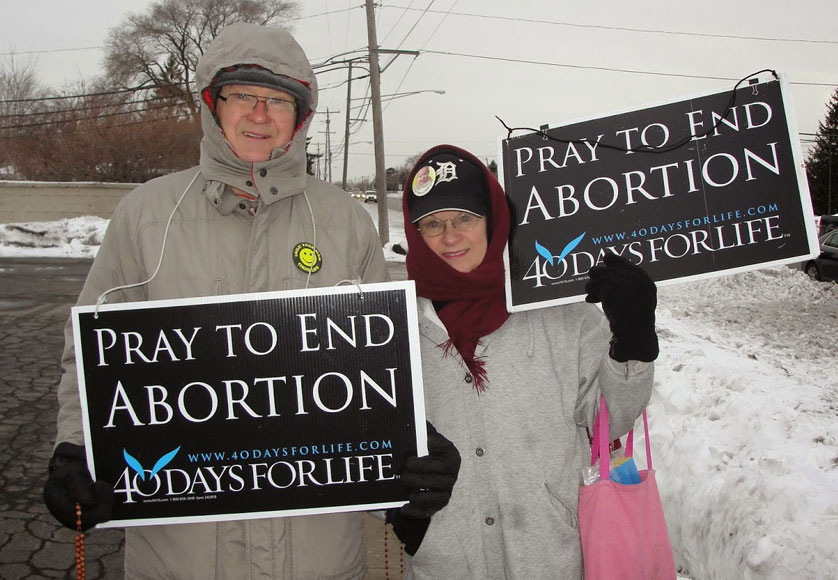 Richard Kucharek and Jenny Pozniak pray and witness outside an abortion clinic in Sterling Heights on March 13 as part of the 40 Days for Life vigil. In addition to protecting the unborn, the pope has also called on Catholics to show mercy and compassion for post-abortive mothers.  