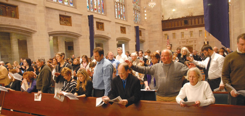 Sponsors pray over candidates and catechumens during a Rite of Election ceremony at the Cathedral of the Most Blessed Sacrament in Detroit.