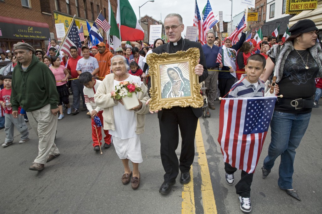 Auxiliary Bishop Donald F. Hanchon, then-pastor of Most Holy Redeemer Church in Detroit, holds an image of Our Lady of Guadalupe as he marches with protesters during a 2007 immigration rally in downtown Detroit. Photo by Jim West.