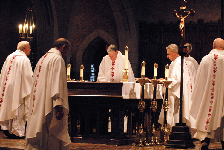 Priest jubilarians venerate the altar at the beginning of a Mass June 19 at Sacred Heart Major Seminary honoring milestone anniversaries of their ordination. Archbishop Vigneron said all those celebrating jubilees have allowed God to play the principal role in their lives.  