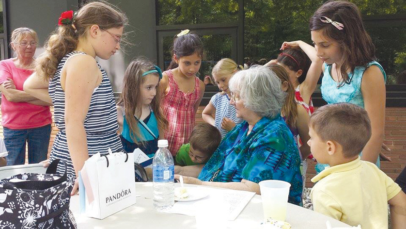 Surrounded by her second-grade students at St. Edward on-the-Lake School in Lakeport, Sr. Faye McFarlane, IHM, reads from a book during her retirement picnic June 1. Sr. McFarlane has taught in Catholic schools for the past 50 years.