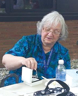 Sr. Faye McFarlane, IHM, opens gifts from students and staff during her retirement picnic June 1.