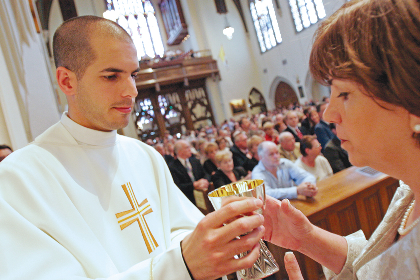 Newly ordained Father Robert Ketcham offers the Communion cup to a woman during his ordination Mass at St. Agnes Cathedral in Rockville Centre, N.Y., June 14. Bishop William F. Murphy of Rockville Centre ordained nine men at the Mass. (CNS photo/Gregory A. Shemitz, Long Island Catholic) (June 23, 2008)