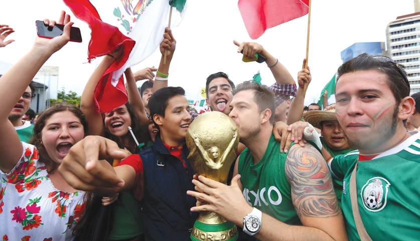 Fans in Guadalajara, Mexico, celebrate June 23 after Mexico beat Croatia, 3-1, in FIFA World Cup play. Mexico qualified for the knockout stage of play and will face the Netherlands June 29. (CNS photo/Ulises Ruiz Basurto, EPA) (June 24, 2014)
