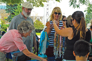 The Legion of Mary shares rosaries with a woman and her children attending the Woodward Dream Cruise in Royal Oak. 