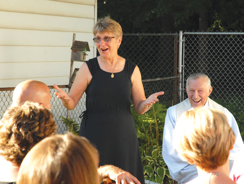 Leona Center shares a laugh Sept. 6 with members of the “Christian Marrieds” group, which has been gathering to support, encourage and pray for one another for 30 years. The Centers credit Fr. Edward Prus, who looks on, with inspiring the idea for the Metro Detroit group when he married them three decades ago. 