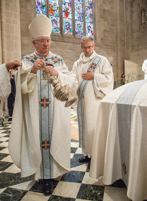 Cardinal Adam Maida, successor to Cardinal Szoka as archbishop of Detroit, blesses his predecessor’s body with incense at the end of the funeral liturgy. 
