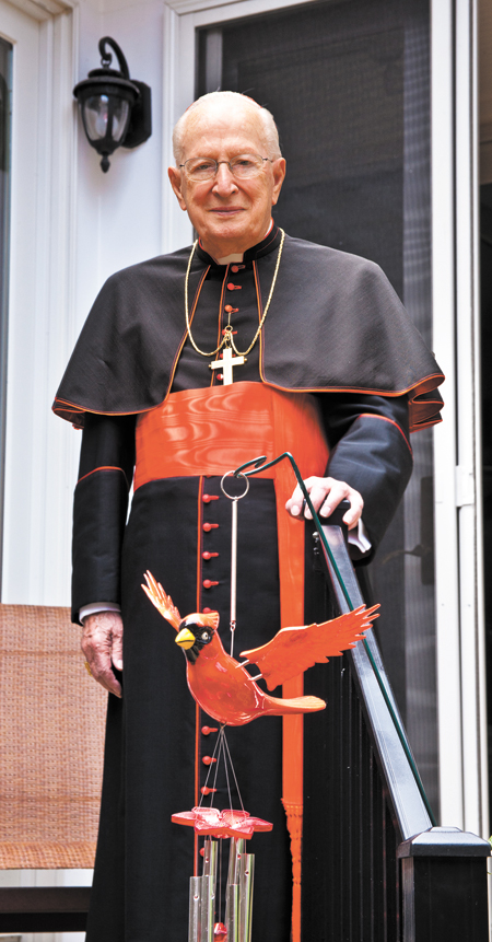 Cardinal Szoka is pictured on his back porch with a cardinal wind chime. 