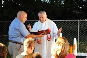 Fr. Edward Prus, who married a number of the couples at the National Shrine of the Little Flower in Royal Oak, celebrates an outdoor Mass at the Centers' home, assisted by Marc Center.