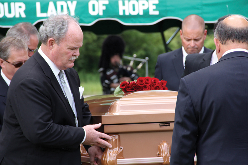 Pallbearers carry a casket of an unclaimed body from the Wayne County Morgue during an interfaith burial service July 9 at Our Lady of Hope Cemetery in Brownstown Township. The Church teaches that the way Catholics care for the bodies of the dead reflects their beliefs and respect for life.
