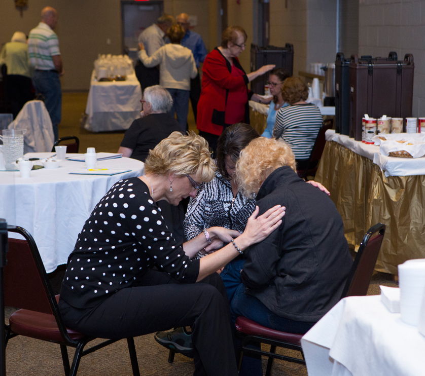 Two women pray over another woman during the ChristLife training conference Sept. 12-13 at SS. Cyril & Methodius Parish in Sterling Heights.  