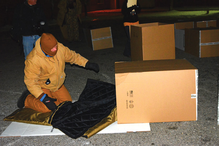 Mike Ritchie, president of Comerica Bank’s Michigan Market and a parishioner of St. Joseph Parish, Trenton, prepares his sleeping bag and box Nov. 20 to guard against the freezing elements during Covenant House Michigan’s “Sleep Out” fundraiser and awareness event. Ritchie, who said he was “layered up pretty good” for the 10-degree temperatures, said his single night outside was nothing compared with what homeless youths and adults in Detroit go through nearly every day.  