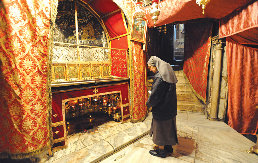A nun prays in front of the star marking the site where according to tradition  Jesus was born in the Church of the Nativity in the West Bank town of Bethlehem Dec. 20. (CNS photo/Debbie Hill) (Dec. 20, 2011)