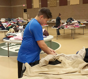 A young confirmation candidate organizes clothing for neighbors in need during Holy Family Parish’s annual “Country Caring & Sharing Coat Drive” on Dec. 13. Parishioners at the Memphis parish have coordinated the drive for nearly 20 years, and recently those from nearby St. Augustine Parish in Richmond have helped out, too.