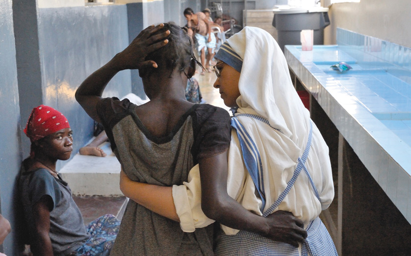 At the "House for the Dying," a hospice for AIDS patients and other seriously ill patients run by the Missionaries of Charity in Port-au-Prince, Haiti, Sister Paula, a Spanish nun, supports a patient in 2009 as she walks. (CNS photo/Paul Jeffrey) (July 19, 2010) See AIDS-VITILLO July 19, 2010.