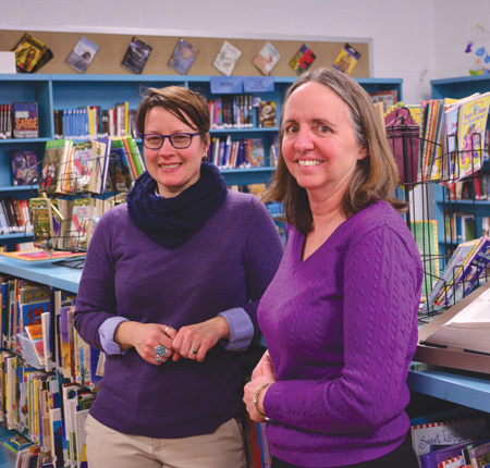 Anita Sevier, right, special projects coordinator at Gesu Catholic School in northwest Detroit, and Rebecca George, the school’s librarian, stand among the many new books in Gesu’s renovated library.