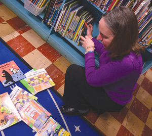 Anita Sevier shows off books written by local children’s authors in Gesu’s renovated library. As part of the school’s partnership with The Book Beat in Oak Park, several of the authors have stopped by the school in recent years to give presentations to students.  