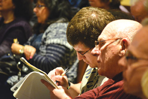 A man takes notes during Staples’ talk, which featured plenty of references to Scripture and the Church fathers. 