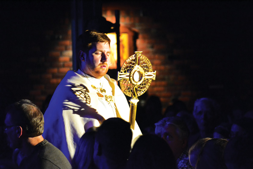 Fr. Steve Pullis processes with the Blessed Sacrament through St. Joseph the Worker Church in Lake Orion during an “Awaken” event Feb. 8.  For more photos, visit gallery.themichigancatholic.com. 