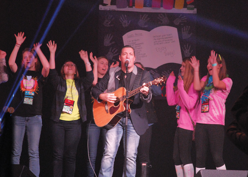 Steve Angrisano, one of the weekend’s keynote speakers for the CYO Rainbow XXXIII conference, invites youths up on stage while singing “Lean On Me.” 