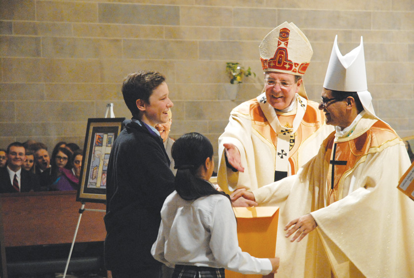 Student representatives receive a medal and award certificate from Archbishop Allen H. Vigneron and Auxiliary Bishop Arturo Cepeda honoring their Christian service efforts during the annual all-schools Mass at the cathedral celebrating Catholic Schools Week.  
