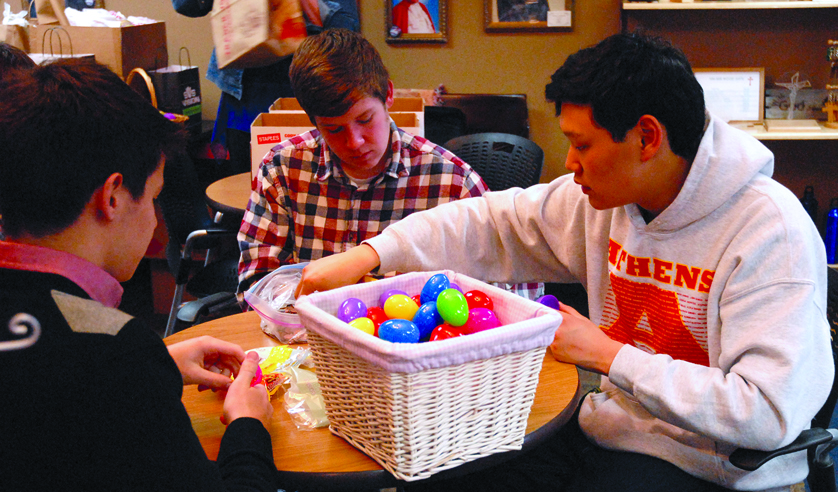 Left to right, Kareem Elhage, Ryan Fitzpatrick and Michael Collison fill eggs with candy and coins for the recipients of Faith@Work’s 2015 Easter Egg Drop. 