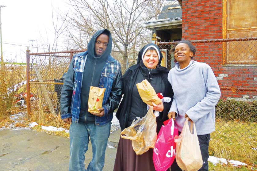 Sr.Francesca Thèrése Bozzo, OSF, distributes lunches and shares a laugh with those she calls her “brothers and sisters of the street.”