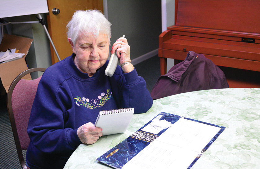Audrey Bolstrum checks her messages while reviewing prayer intentions that have come in through St. John Bosco Parish’s special “prayer line.” Bolstrum has operated the intercession ministry at the Redford parish for the past 19 years. 