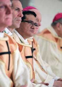 Auxiliary Bishop Arturo Cepeda looks on with other bishops as Archbishop Vigneron gives his homily.