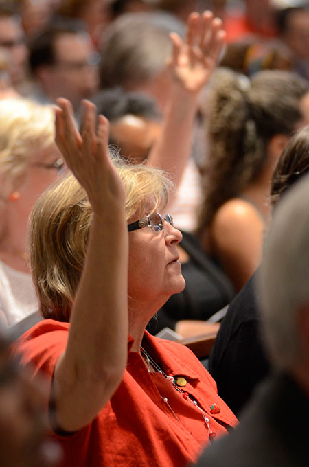 A member of the charismatic community raises her hand in prayer May 23 during the vigil Mass of Pentecost at the cathedral May 23.