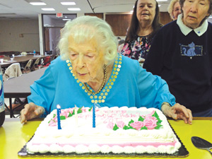 Edna Julian, an active volunteer at St. Richard Parish in Westland, blows out the candles on her 102nd birthday celebration at the parish. Julian, who converted to Catholicism at age 69, has spent the last three decades living her faith vibrantly.