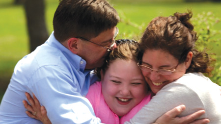 Chip and Maureen Clearwater hug their daughter, Olivia, who is enrolled in Veritas Christi's online courses. "Veritas Christi will provide our daughter with what she needs to be successful spiritually, academically, and emotionally, " Chip Clearwater told The Michigan Catholic.