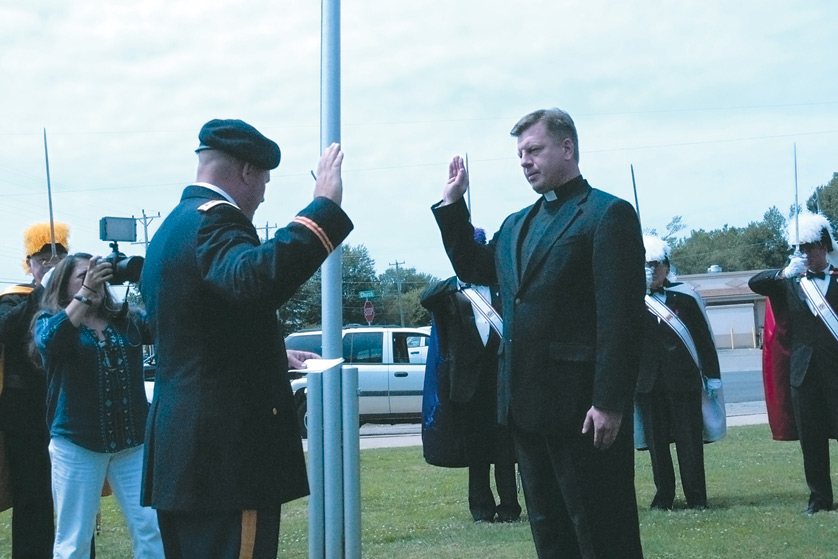 Fr. Tomek Maka is commissioned a lieutenant in the United States Navy on Aug. 9, as his brother-in-law, U.S. Army Maj. Ken Kozak, officiates at a swearing in ceremony at Immaculate Conception Parish in Ira Township. Fr. Maka will be one of just 48 priest-chaplains serving the U.S. Navy, Marine Corps, Coast Guard and Merchant Marines.