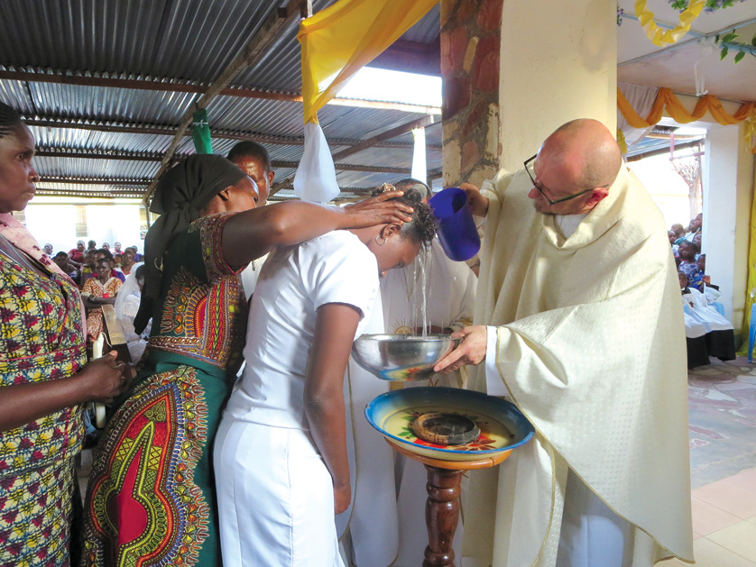 Fr. Benjamin Kosnac, pastor of SS. Cyril and Methodius Parish in Sterling Heights, baptizes new members of Holy Family Parish in Kagongwa, Tanzania, this month during a mission trip to the African village. SS. Cyril and Methodius has developed a "sister parish" relationsihp with the Tanzanian church since 2007.
