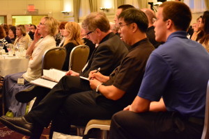 Clergy and lay ministers take notes during several of the presentations.