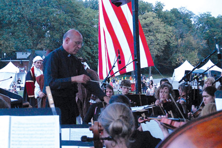 Fr. Eduard Perrone, pastor of Assumption Grotto Parish in Detroit, conducts a 52-piece orchestra during the event.