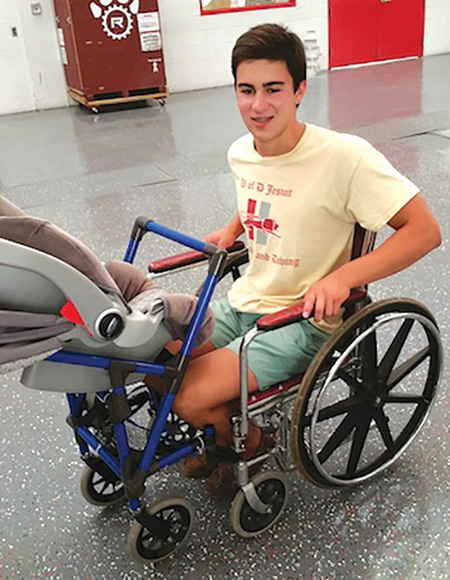 University of Detroit Jesuit High School senior Alden Kane demonstrates his invention, which will allow a wheelchair-bound mother to easily transport her baby.
