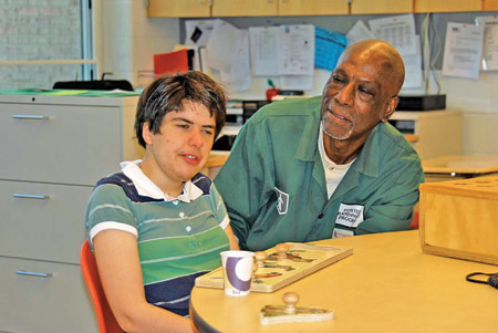 Andrew Grimes, a volunteer with Catholic Charities of Southeast Michigan's Foster Grandparent Program, works with a young boy at the Wing Lake Developmental enter in Bloomfield Hills. The Foster Grandparent Program matches senior volunteers with at-risk youth who need mentoring. Courtesy of Catholic Charities of Southeast Michigan