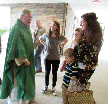 Msgr. Charles Kosanke greets parishioners at St. Regis Parish in Bloomfield Hills after Mass. Kelly Luttinen | Special to The Michigan Catholic