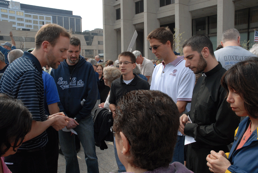 Now-Fr. Patrick Gonyeau, then a seminarian at Sacred Heart Major Seminary, leads a group of young men in prayer during a 2012 religious freedom rally in Detroit. Fr. Gonyeau serves as one of four regional directors of the Watchmen, a gorup for men ages 16-55 who meet to discuss questions pertaining to vocations. Mike Stechschulte | Michigan Catholic file photo