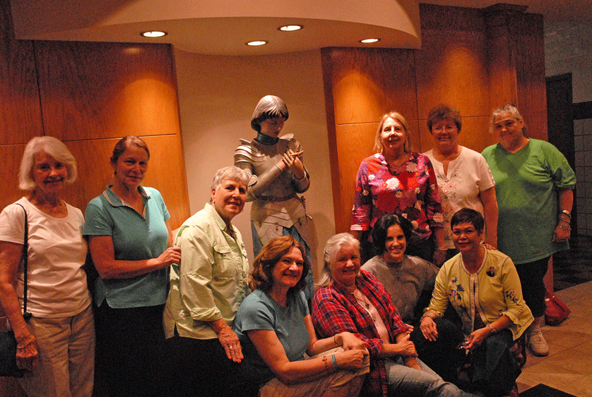 Volunteers for St. Joan of Arc Parish's Center for Exceptional Children gather around a statue of St. Joan of Arc at the school. The center, which offers those of all ages with learning disabilities a safe place to learn about the Lord, was recognized Sept. 20 during the Archdiocese of Detroit's annual Mass for Persons with Special Needs. Dan Meloy | The Michigan Catholic